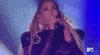 Celebrity gif. Beyonce sings as she holds a microphone with both hands and raises her hands prayer-like. 