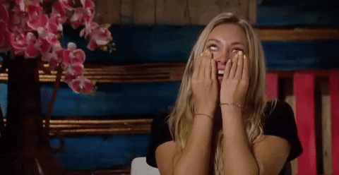 Reality TV gif. Corrine on The Bachelor looks above her as her hand pulls on her cheeks as if tearing away the tears. 
