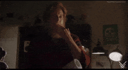 Video gif. Interior of a bedroom. An actor with a long beard kisses his fingers and then touches the forehead of someone who is laying in bed.