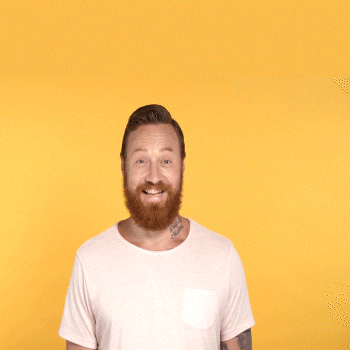 Video gif. Man in a white t-shirt with arm tattoos and a large orange beard smiles and gives two thumbs up on a yellow background, text reads “Awesome.”