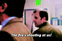 The Office gif. Ed Helms as Andy panics and yells at his coworkers, "the fire's shooting at us!" which appears as text.