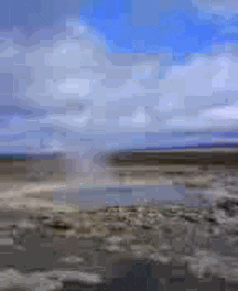Video gif. A geyser bubbles then water explodes forcefully into the sky. 