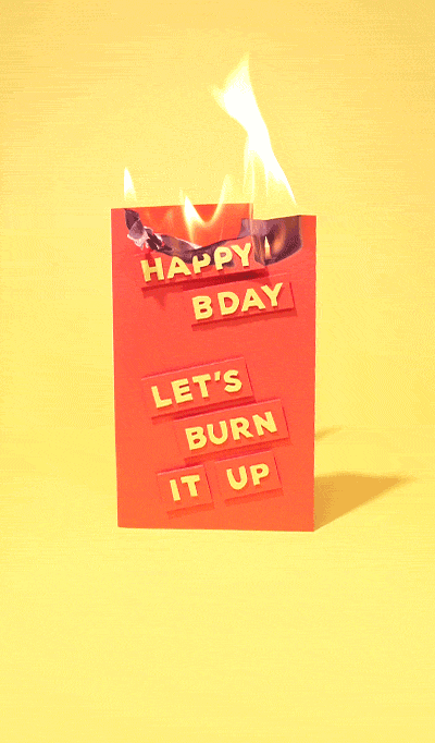 Video gif. Red birthday card standing up on display with the words "Happy Birthday" and "Let's burn it up" on it. The card is slowly going up in flames against a yellow background. 