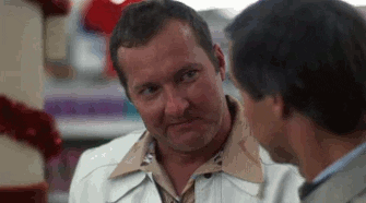 Movie gif. Randy Quaid as Cousin Eddie in National Lampoon's Christmas Vacation gives the okay hand sign and winks while saying "Okay!"