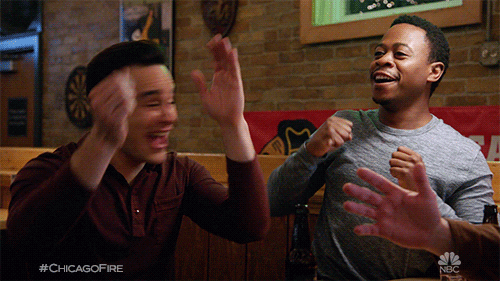 TV gif. Daniel Kyri as Darren and Alberto Rosende as Blake in Chicago Fire turn and clap in excited celebration. 