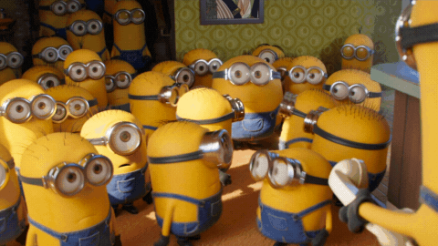 Movie gif. A bunch of minions from Minions: Rise of Gru are standing in a home and they simultaneously turn to look at one giant minion. The camera zooms in on the giant minion, who looks shocked and scared as they give us an awkward, apologetic grin. 