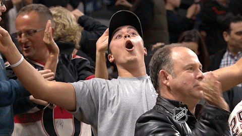 Sports gif. Guy at NHL Bruins game cheering and screaming intensely.