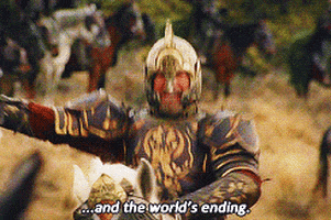 Movie gif. Theoden played by Bernard Hill from Lord of the Rings: Return of the King in full battle armor, riding a white armored horse. He screams and charges hyping his army up with his sword extended and rage in his face. Text, "...And the world's ending." 