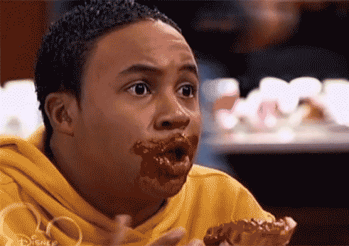 Disney gif. Orlando Brown as Eddie in That's So Raven basks in pleasure, eyes rolling back into his head, chocolate in his hands and all over his mouth and chin.
