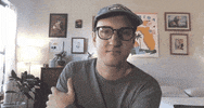 Celebrity gif. Tyler Menzel, in a home environment, appears to be listening, nodding slightly and then saying "awesome," which appears as text.