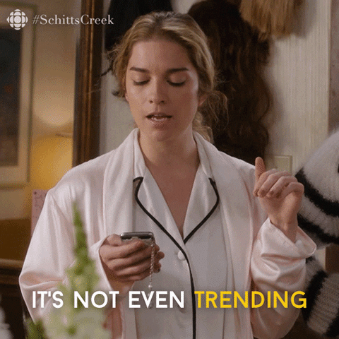 Schitt's Creek gif. Annie Murphy as Alexis is in her pajamas and looks down at the smartphone she’s holding. She looks disgusted and a bit shocked as she says, “It’s not even trending, which is actually kind of sad,” and then she looks at her brother next to her for his opinion. 