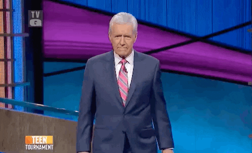 TV gif. Alex Trebek on Jeopardy looks directly at us and steps closer as he points at us with both hands. 