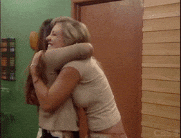Reality TV gif. Two women from Big Brother are ecstatic as they hug closely and jump around. Their eyes are closed and their faces are filled with happiness.