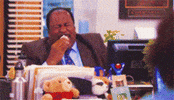 The Office gif. Leslie David Baker as Stanley laughs hysterically at his desk and dabs tears from his face with a tissue.