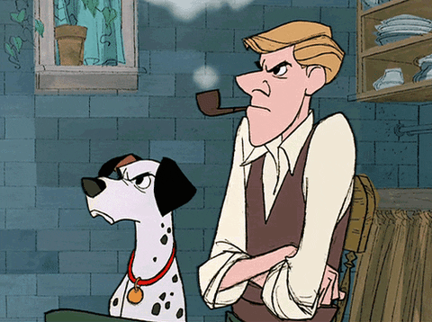 Disney gif. Pongo and Roger from 101 Dalmatians are sitting at a table and both are in a huff. Their brows are both furrowed and Roger has his arms crossed over his chest as he puffs on a pipe.