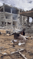 Palestinian Women Make Bread Among Ruined Buildings