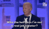 Video gif. President Joe Biden stands behind a podium at the 2024 White House Correspondents' Dinner. Feigning annoyance, he looks to his right and jokes, "Who the hell says I’m not a real job creator?"