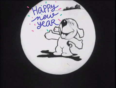Digital art gif. A dog is clapping with both paws extended fully and a broad smile fills their face. Their head is tilted up and their eyes are closed in happiness and the text reads, "Happy new year!"
