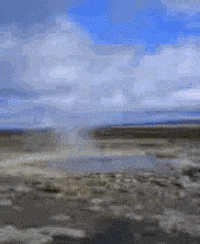 Video gif. A geyser bubbles then water explodes forcefully into the sky. 