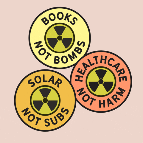 Digital art gif. Three circles with nuclear warning symbols inside. One circle has text that says, "Books not bombs," and the warning symbol transforms into a book. Another circle has text that says, "Healthcare not harm," and the warning symbol transforms into a plus sign. And the last circle has text that says, "Solar not subs," and the warning symbol transforms into a wind turbine.