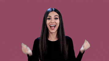 Celebrity gif. Victoria Justice does a happy dance, waving her fists in the air while jumping and grinning.