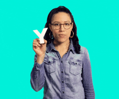 Video gif. Girl looks at us with an annoyed look on her face, holding the letter Y in her hand, and saying, “Why?”