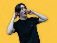 Celebrity gif. Kino from KPOP group Pentagon covers his ears with both hands and shakes his head, looking around.