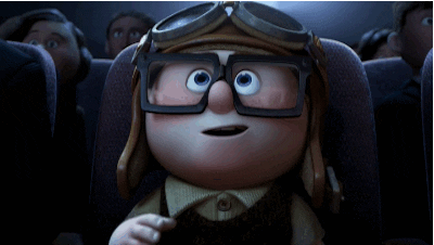 Cartoon gif. An awestruck young Carl Fredricksen from Up wears an aviator cap while watching a movie in a theater. He pulls goggles over his eyes, and gives a smiling thumbs-up to the screen.