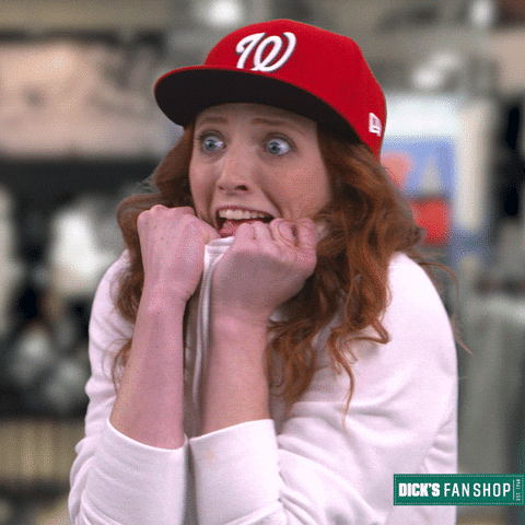 Sports gif. Woman donning a red Washington Nationals baseball cap panickedly pulls the front of her white hoodie over her face, as her mouth hangs open and her blue eyes are wide with anxious energy. A Dick's Fan Shop is displayed in the bottom right corner.