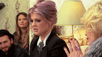 TV gif. Kelly Osbourne raises her eyebrow in annoyance at Joan Rivers on the In Bed with Joan show.