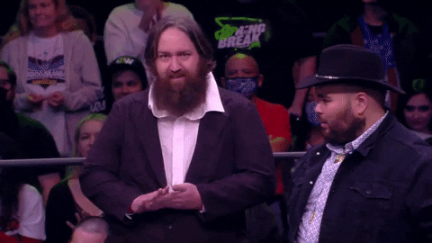 Sports gif. Leroy Patterson and Howdy Price in their debut for Freakshow Wrestling. Leroy gives us a crazy smile as he waves at the camera and Howdy lifts his cowboy hat.