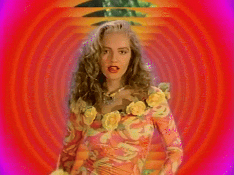 Video gif. A retro edit of a young woman wearing a floral dress who points at us and says, "You." The background warps in on her, adding a dramatic effect.