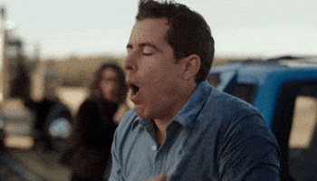 TV gif. Jason Jones as Nate in The Detour leans over on the side of a road and pretends to throw up while his friends watch behind him.