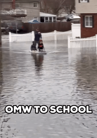 Man Paddles Children to School on Flooded Street