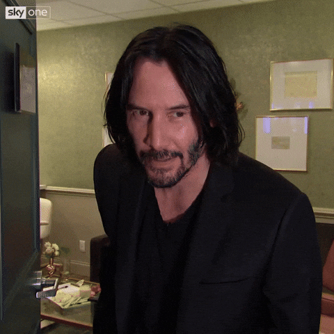Celebrity gif. Keanu Reeves on The Late Late Show with James Corden. He looks at us with a smile and puts his hand over his heart and bows his head.