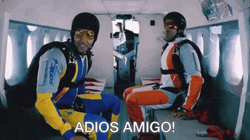 Movie gif. Farhan Akhtar as Imraan and Hrithik Roshan as Arjun in Zindagi Na Milegi Dobara sit in a plane wearing skydiving gear as Imraan shouts in Spanish, "Adios amigo!"