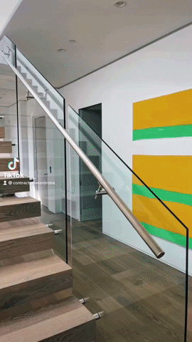 Glass rail staircase complemented by works of art