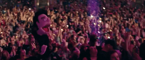Music video gif. In the Panic! At The Disco video for Hey Look Ma, I Made It, a muppet of Brendon Urie dances with his mouth gaping open in front of a crowd showered with confetti.