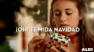 Ad gif. Teen girl looks at the tag of a small Christmas gif and snarls, disappointed, and puts it down. Text, "Oh! Temida navidad."