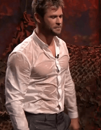 Celebrity gif. Chris Hemsworth dances seductively and wears a soaking wet white shirt as he pours water on himself and rubs his chest. 