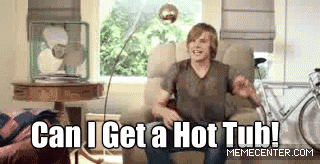 Video gif. A man sitting in an armchair yells out, "Can I get a hot tub!" and a hot tub suddenly appears in his living room.