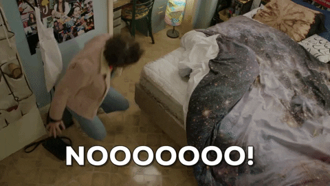 TV gif. Ilana Glazer as Ilana in Broad City. She's in her room and she falls to her knees, raising her fists to the air as she wails in despair, screaming "Noooooo!"