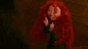 Disney gif. Merida hops excitedly, holding up her fists and smiling as her red curly hair bounces.
