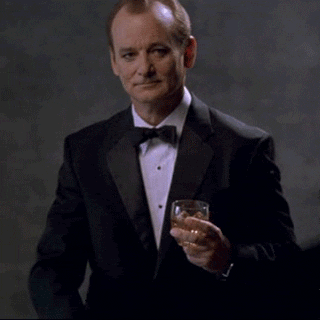 Movie gif. Bill Murray as Bob in Lost in Translation wears a suit and bowtie while holding a glass of liquor. With a raised eyebrow, he sluggishly points ahead. 