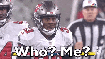 Sports gif. Jordan Whitehead of the Buccaneers is in full uniform on the field as he stares another player down and goads them, saying, "Who? Me?"