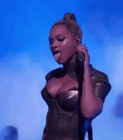 Celebrity gif. Beyonce, in a sexy bustier and tight ponytail, grooves and grinds, sticking her tongue out seductively.