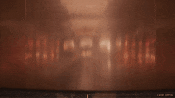 Trailer gif. A scene from the trailer of "Deadpool & Wolverine" shows an elevator door opening at the Time Variance Authority, revealing a masked Ryan Reynolds as Deadpool effortlessly rising from a full split with just his legs. 