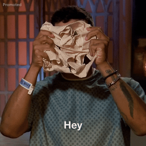 TV gif. Bachelorette contestent Jonathon Johnson reveals face from the bunched up fabric medical bandage he is holding and proceeds to say "hey".