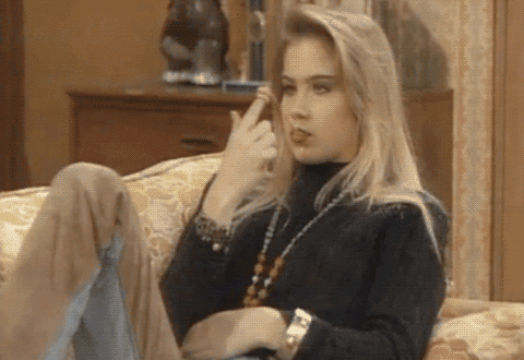 TV gif. Christina Applegate as Kelly in Married with Children. She's lounging on the couch and is supremely uninterested with what's going on, as she twirls a piece of gum she has in her mouth.