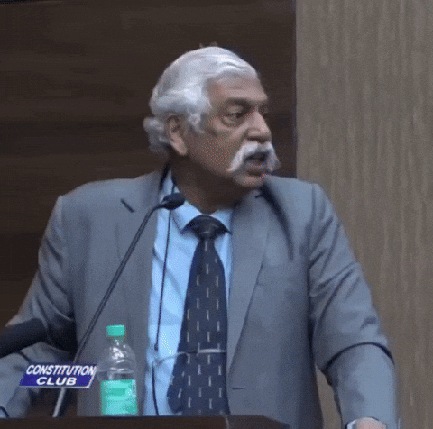 Video gif. An Indian man stands at a podium with a serious expression on his face as he says, “Yeh koi randi khana hai.” He gets more angry and repeats it, with more vitriol the second time.